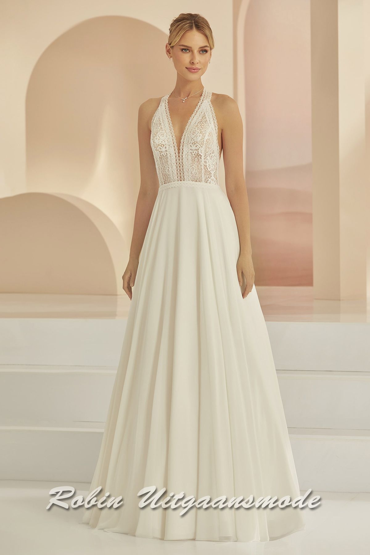 Moderne bruidsjurk met gebloemd kant, een diepe V-hals, haltersluiting en chiffon rok met sleep.