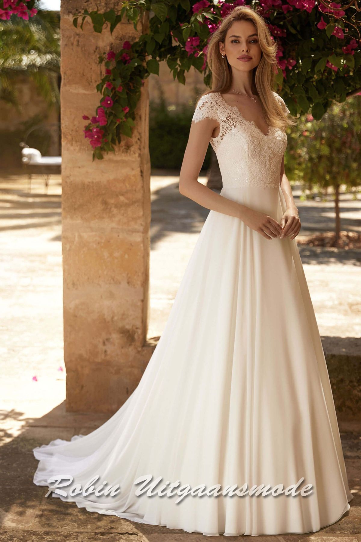 Romantische A-lijn trouwjurk met kleine mouwtjes en V-hals van kant en een wijd uitlopende chiffon rok met sleep.