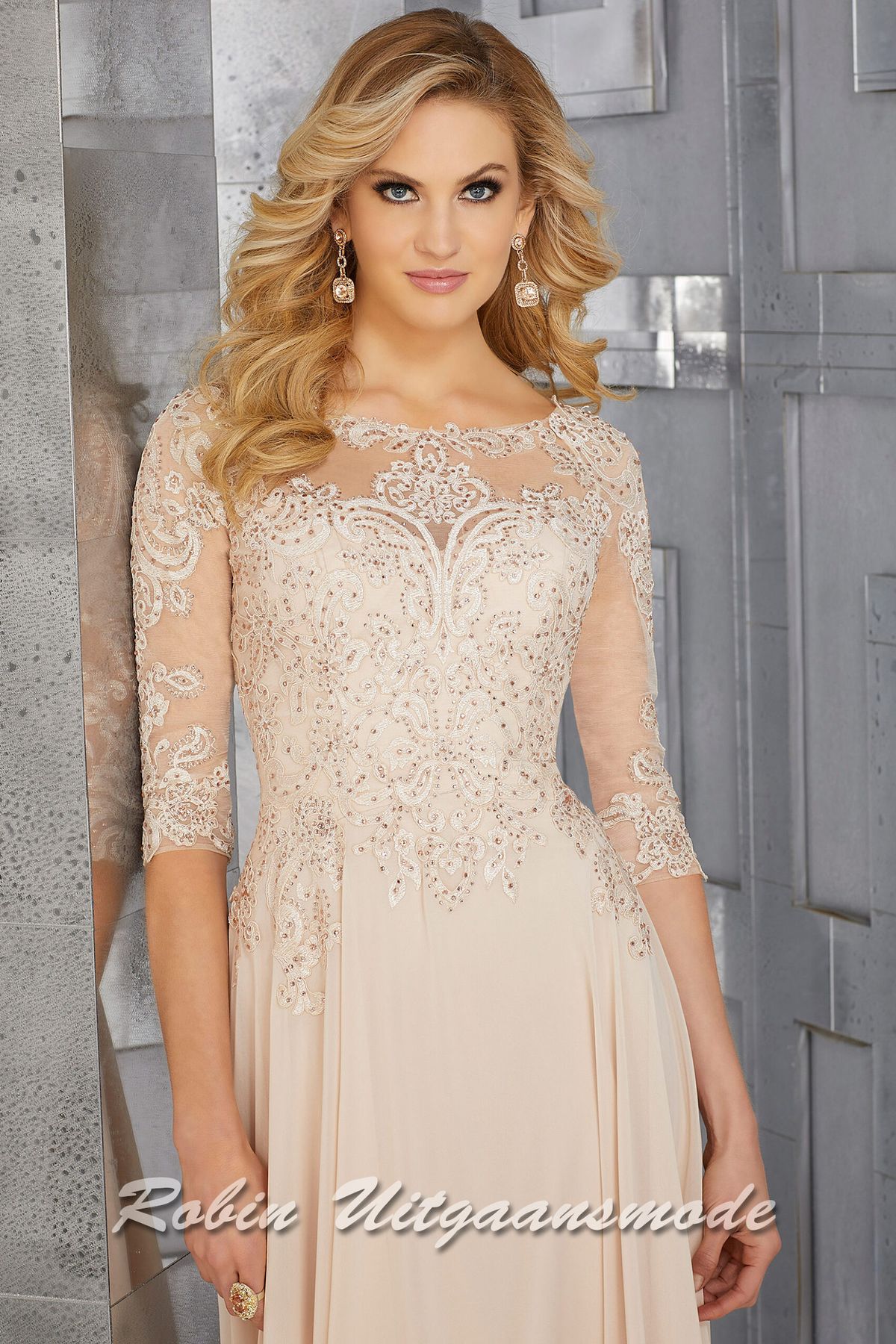 Champagne avondjurk met driekwart lange mouwen, boothals, een geborduurd lijfje met kristallen en een chiffon rok