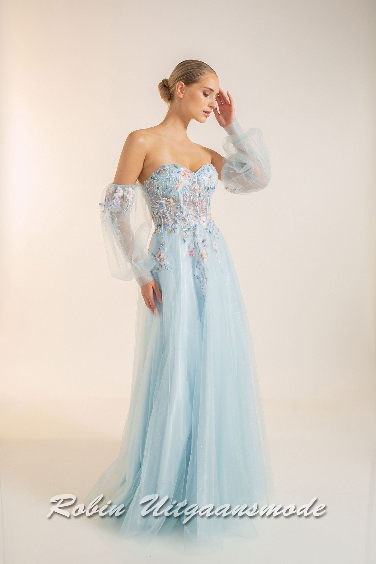 Strapless lichtblauwe galajurk met bloemen lijfje, losse pofmouwen van tule en springerige rok van soft tule