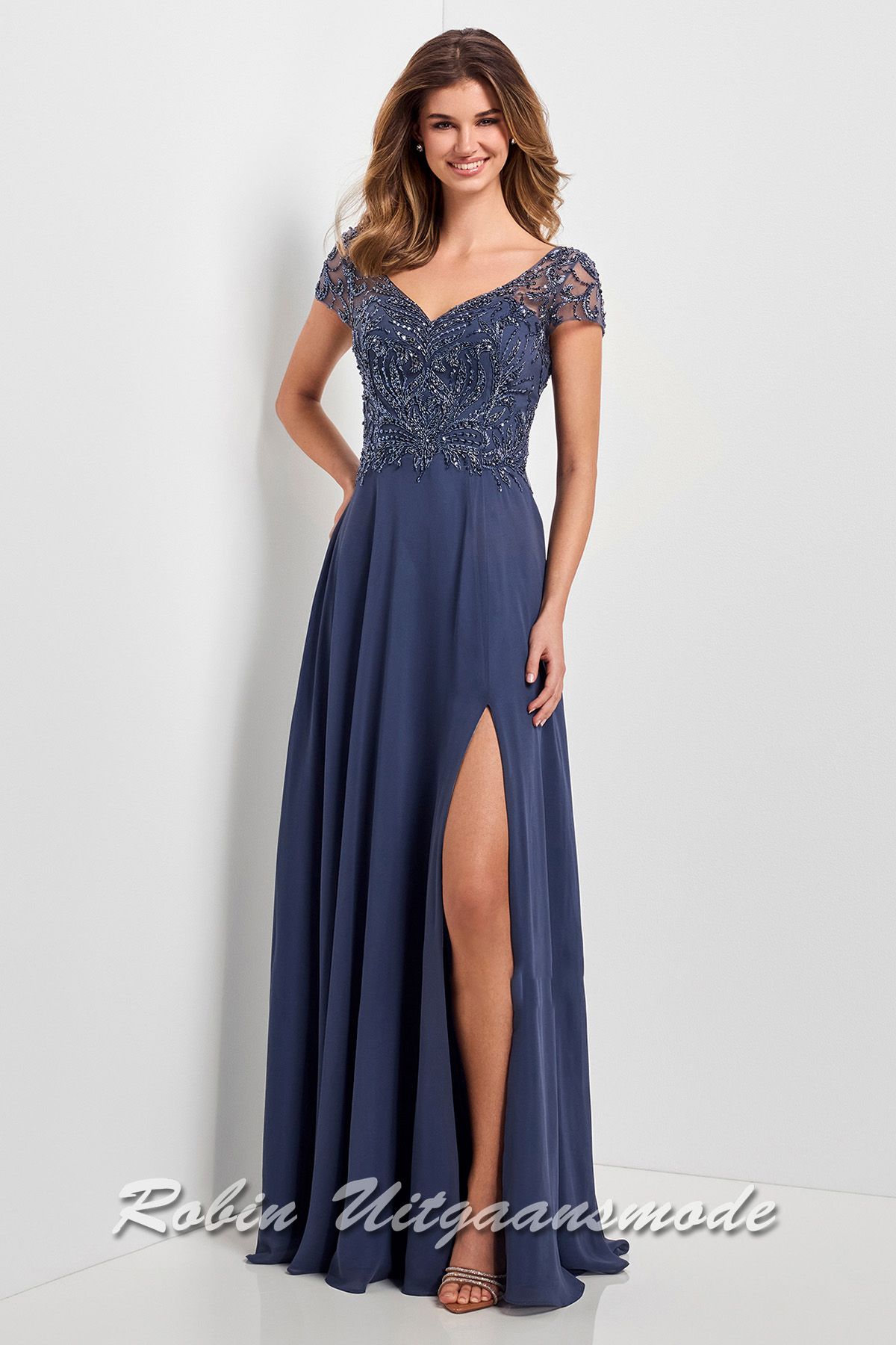 Rookblauwe lange avondjurk met kanten lijfje versierd met sprankelende steentjes, kapmouwtjes en chiffon rok met split