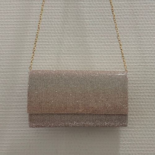 Lange enveloptas in abrikooskleur met heldere kristallen, hangend aan de ketting