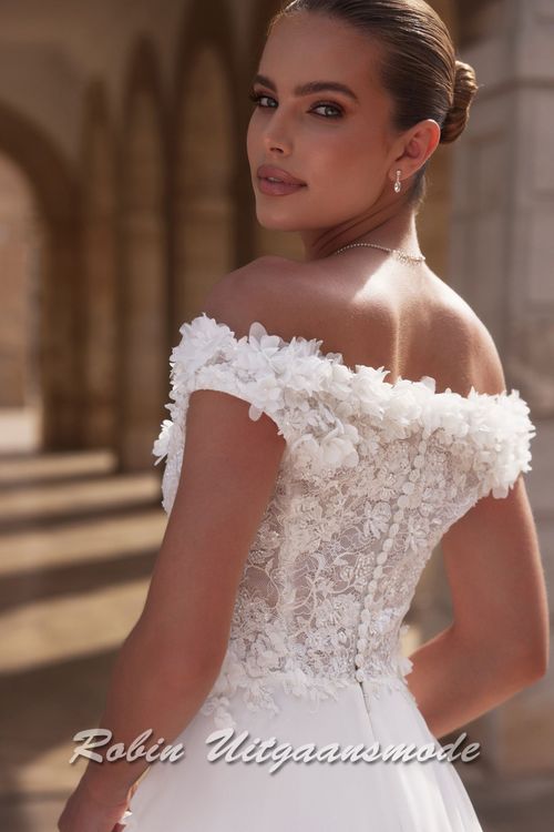 Achterkant van de Off-shoulder trouwjurk met kanten lijfje,  een bloemen versierde halslijn, sluikvallende chiffon rok met semi lange sleep