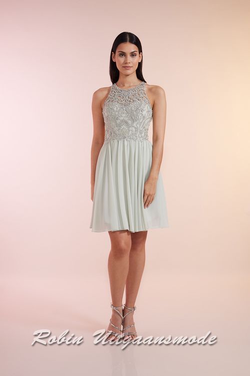 Mint groen cocktailjurk met hooggesloten kanten lijfje, blote schouders en een geplooide chiffon rok tot net boven de knie