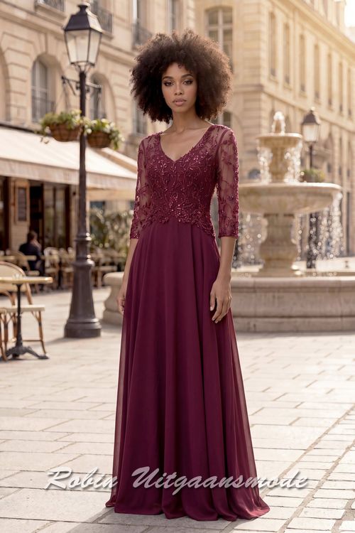Bordeauxrode geklede avondjurk met kanten lijfje, driekwart mouwen, een V-hals en sluikvallende chiffon rok met plooien