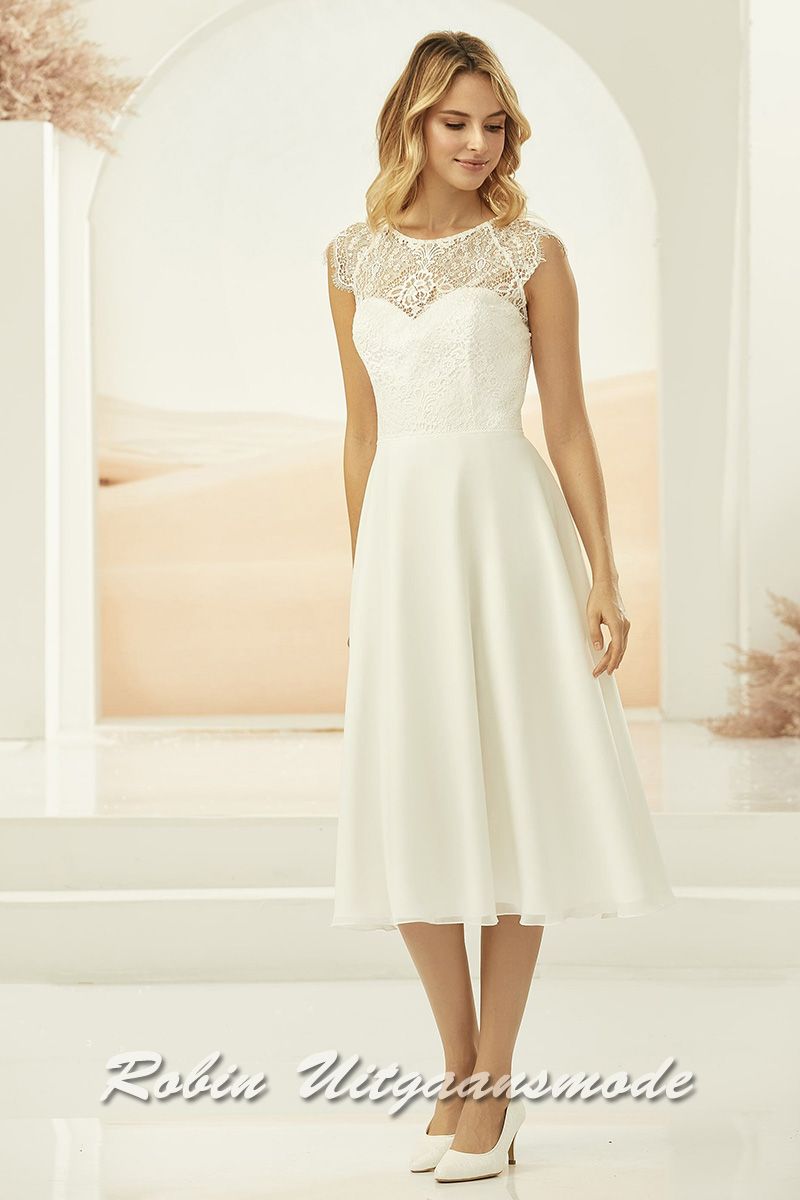 Korte bruidsjurkje met een heart-shaped lijfje van zeer fijn bruidskant, kleine geschulpte kapmoutjes en zwierige chiffon rok.